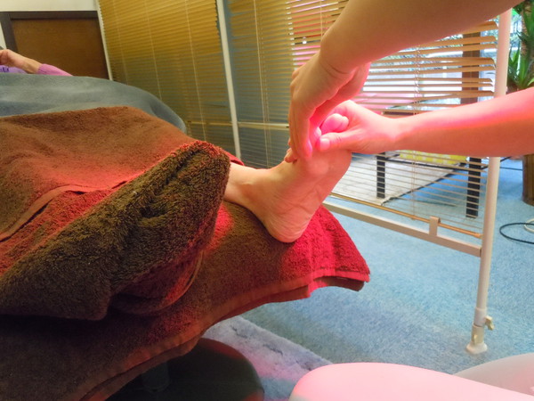 足の親指部分を丁寧にマッサージする足つぼマッサージ（リフレクソロジー）の画像